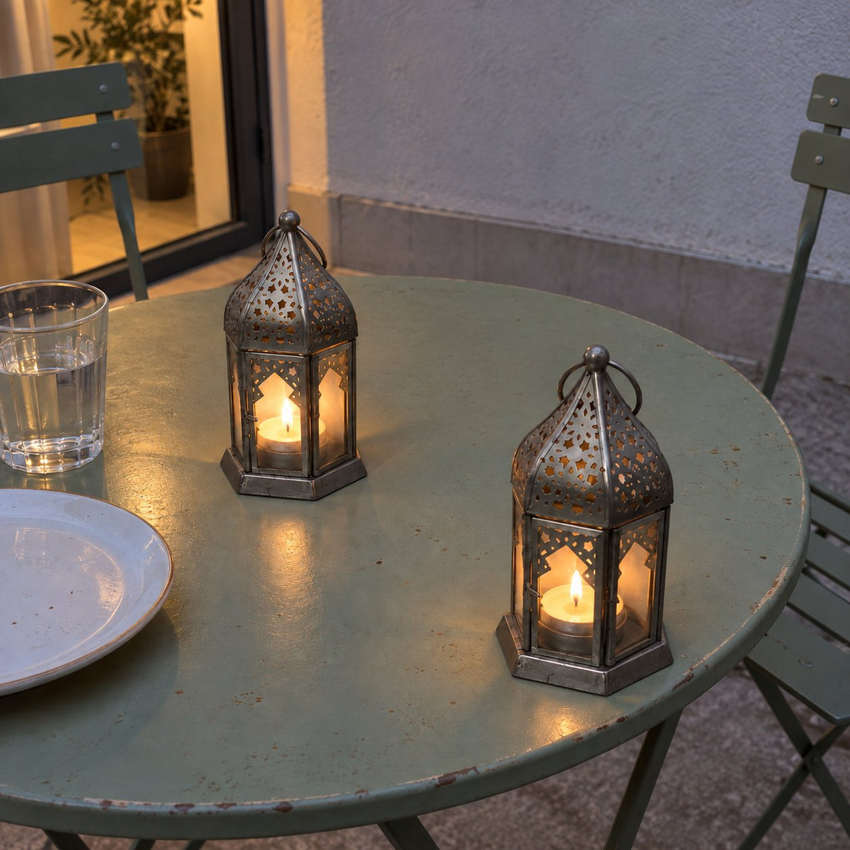 Lanternes Fanous allumées sur une table de terrasse au crépuscule